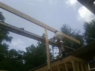 Carpenter setting a ridge beam over a new addition frame — Ice Dam Removal by Roofing Brothers in Buckland