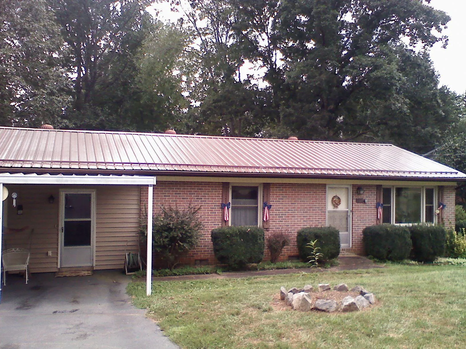 Bronze metal roof and carport on a brick ranch home — Roof Repair work by our crew in Buckland